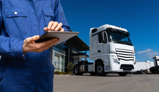 Manager with a digital tablet next to trucks. Fleet management.